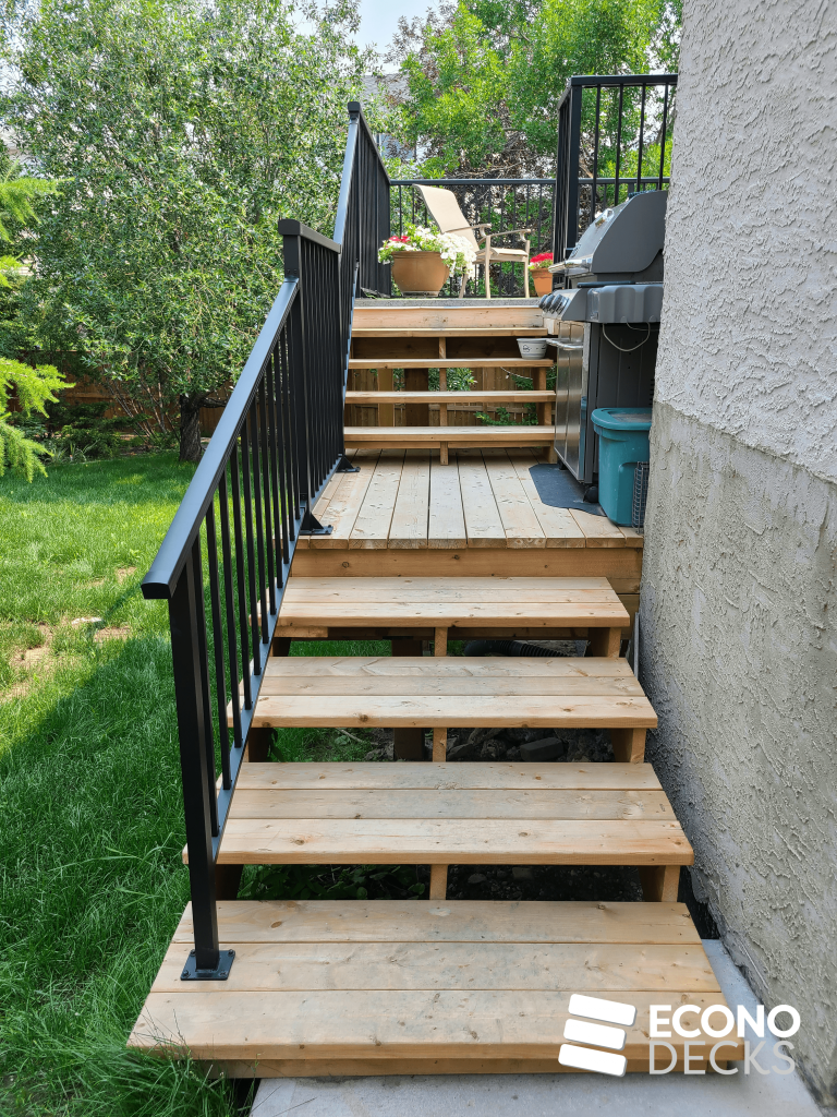 wood decking leading to vinyl deck with black railing